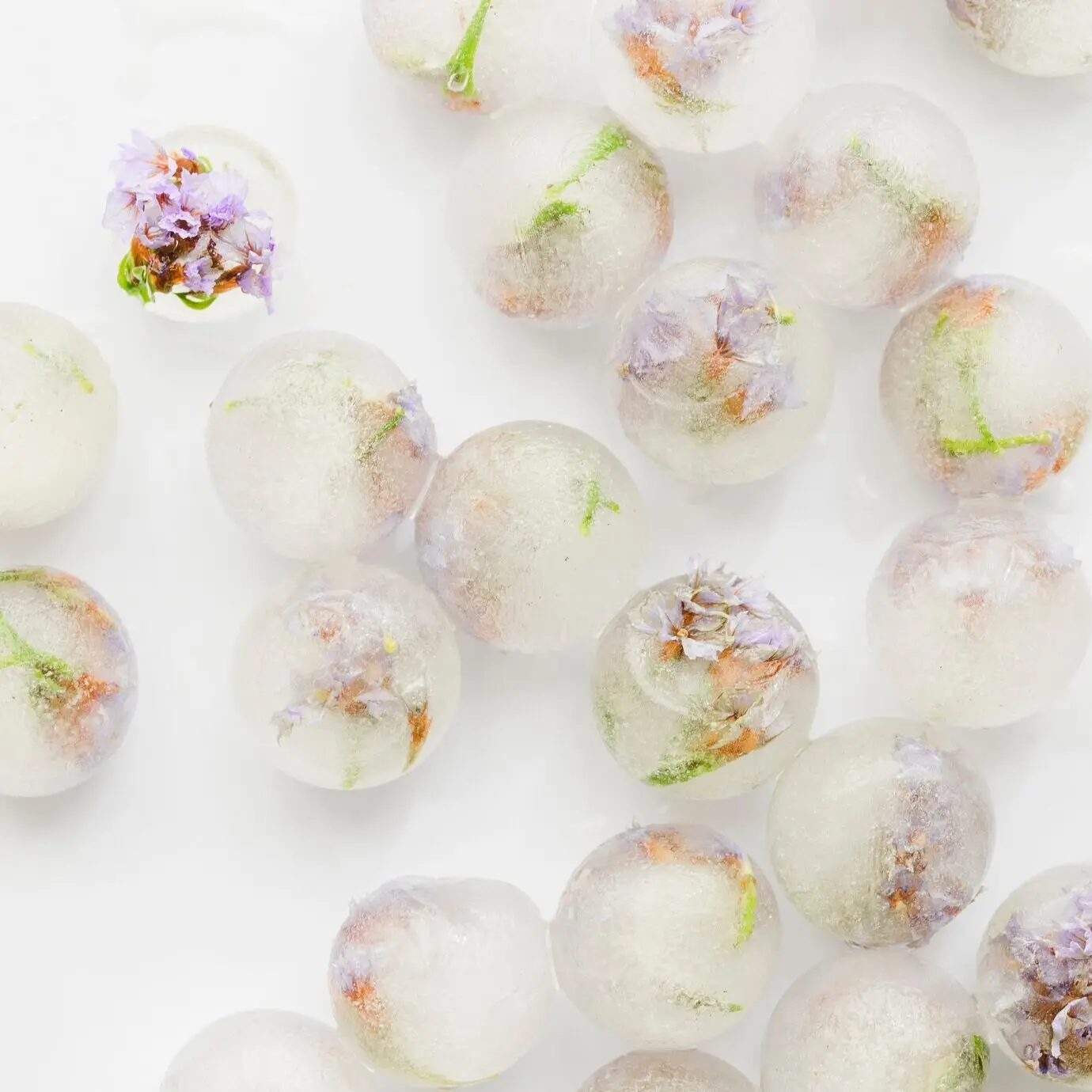 Pinkfarbene Blütchen in Eisbällen